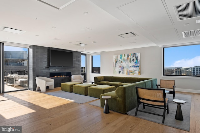 living room with a large fireplace and light wood-type flooring