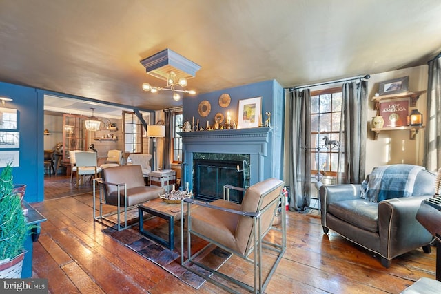 living room featuring a fireplace, a chandelier, and hardwood / wood-style floors