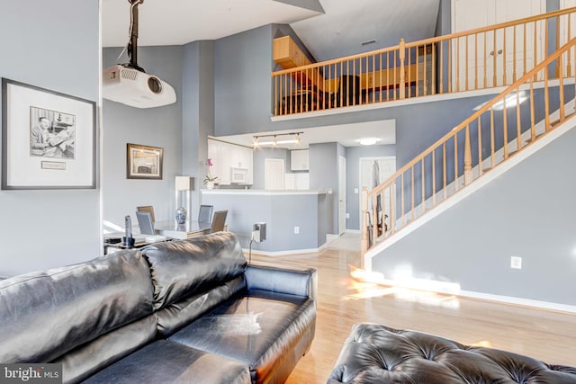 living room with light hardwood / wood-style flooring and a high ceiling