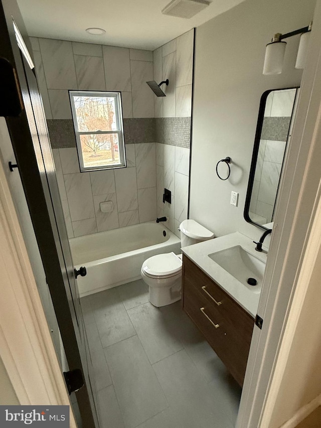 full bathroom featuring tiled shower / bath, vanity, and toilet