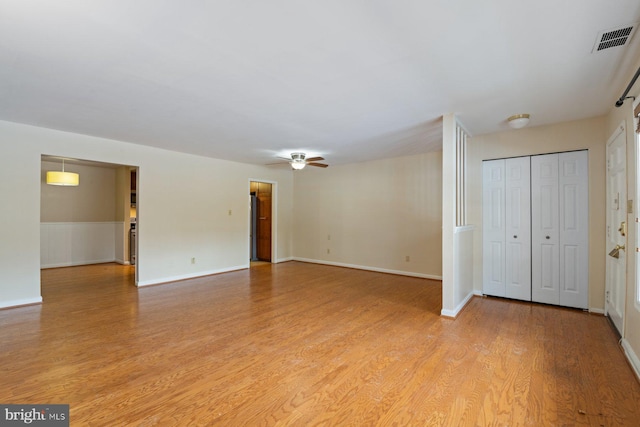 empty room with ceiling fan and light hardwood / wood-style floors