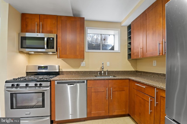 kitchen with dark stone countertops, sink, and appliances with stainless steel finishes