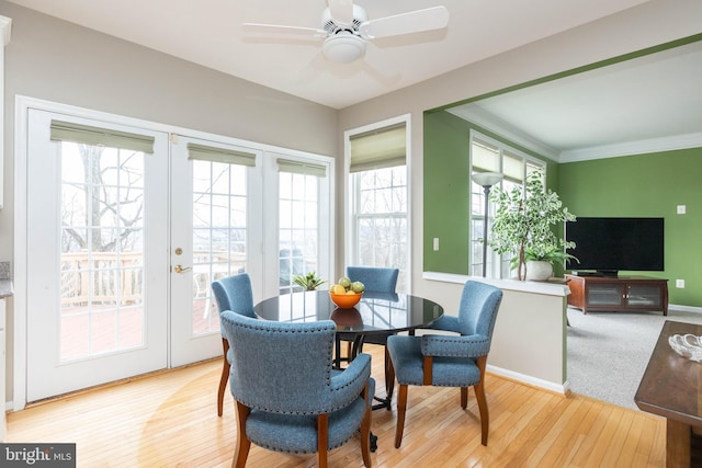 dining space with ceiling fan, french doors, light wood-style flooring, and baseboards