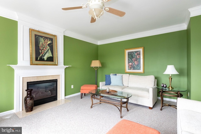 carpeted living room with ornamental molding, ceiling fan, baseboards, and a premium fireplace