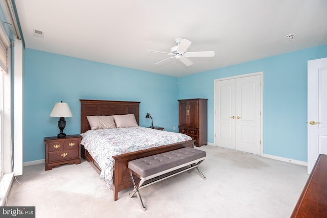 bedroom with light carpet, baseboards, visible vents, a ceiling fan, and a closet