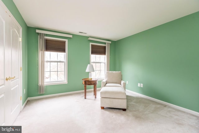 living area with carpet flooring, visible vents, and baseboards