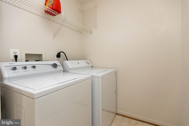 clothes washing area featuring laundry area, independent washer and dryer, and baseboards