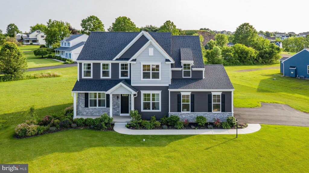 view of front of property featuring stone siding and a front yard