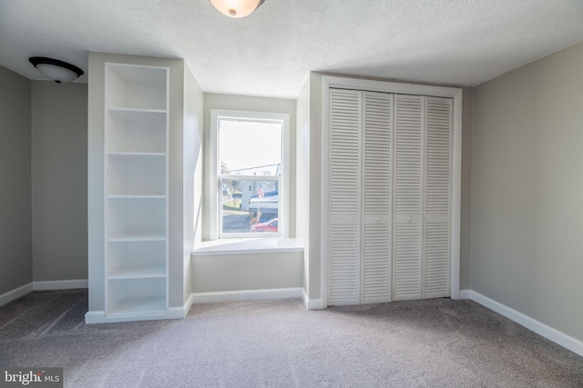 unfurnished bedroom with carpet floors, a closet, and a textured ceiling