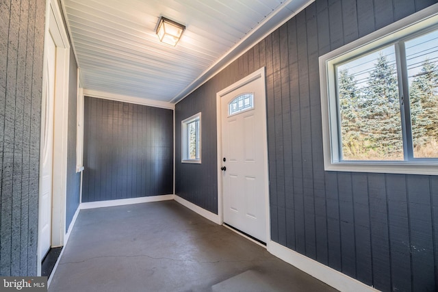 entryway featuring a healthy amount of sunlight and wooden walls