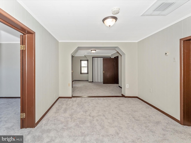 empty room featuring light colored carpet and ornamental molding