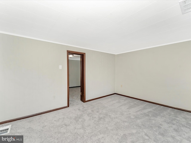 carpeted spare room featuring ornamental molding