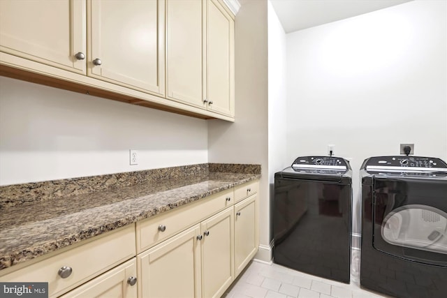 laundry room featuring light tile patterned floors, washing machine and dryer, and cabinets