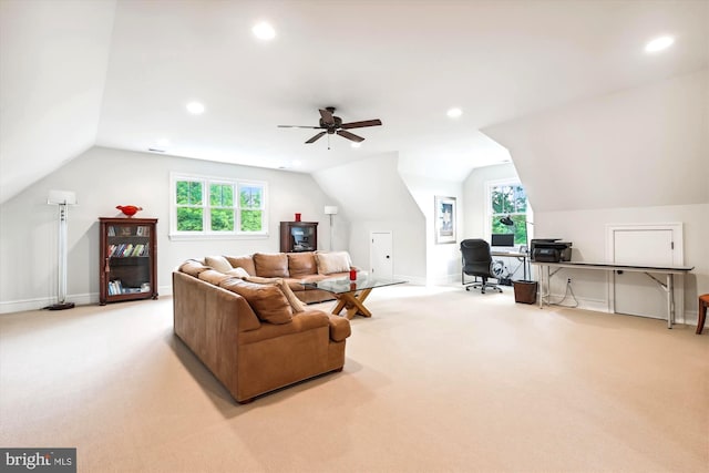 living room with lofted ceiling, light carpet, and a wealth of natural light