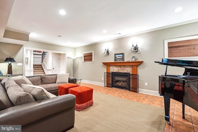 living room featuring crown molding, a tiled fireplace, and light tile patterned floors