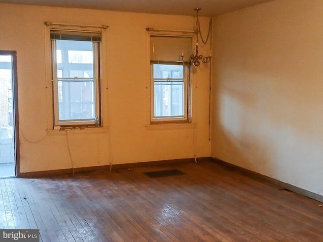 spare room featuring dark hardwood / wood-style flooring and a wealth of natural light