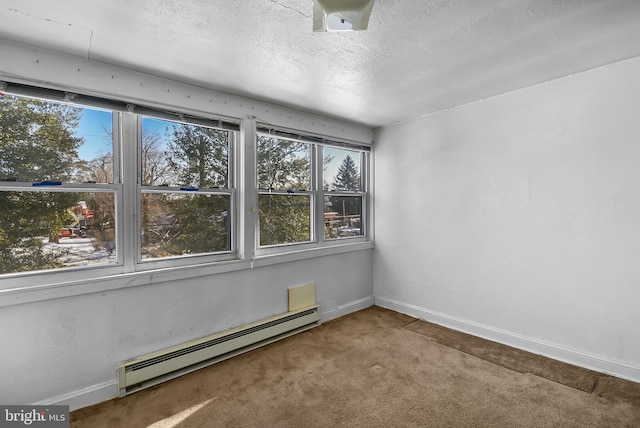 carpeted spare room featuring a baseboard radiator and a textured ceiling