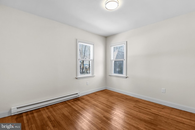 unfurnished room featuring hardwood / wood-style flooring and a baseboard radiator