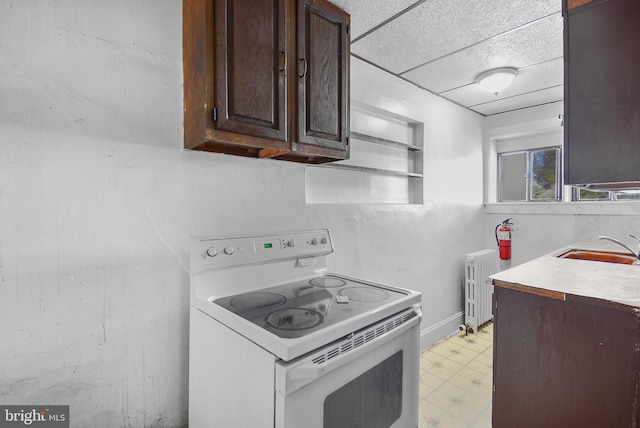 kitchen with dark brown cabinets, radiator, sink, and electric stove