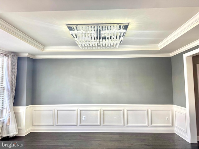 unfurnished room with dark hardwood / wood-style flooring, ornamental molding, and a raised ceiling