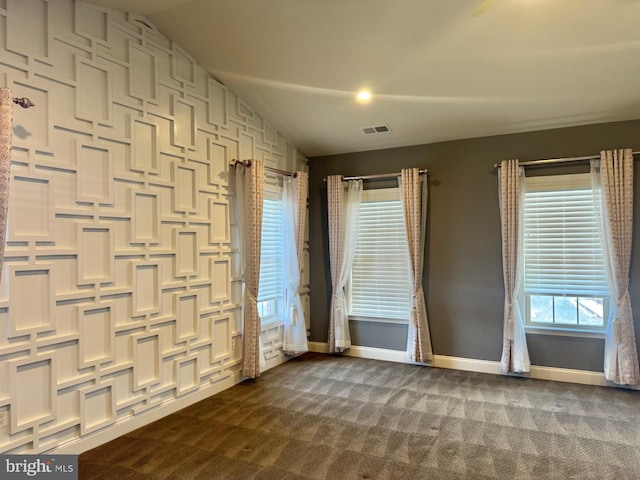 carpeted empty room featuring vaulted ceiling