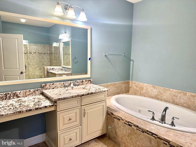 bathroom with vanity, tile patterned flooring, and tiled bath