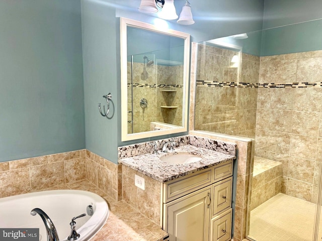 bathroom with vanity and shower with separate bathtub