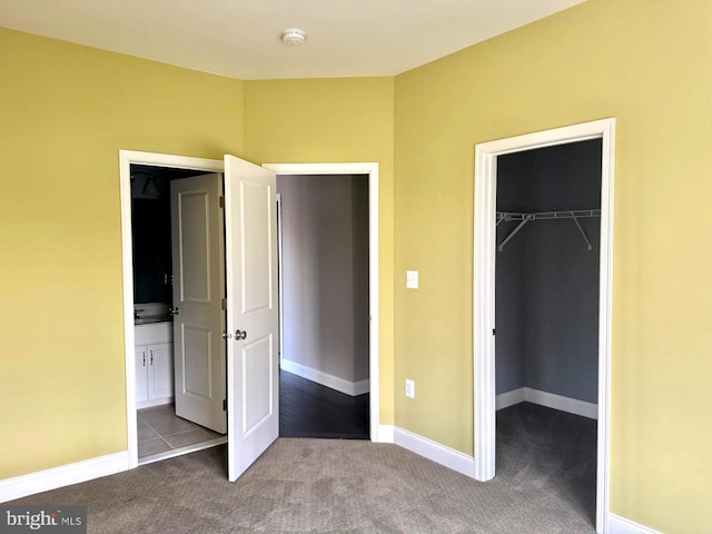 unfurnished bedroom featuring a spacious closet, light colored carpet, and a closet