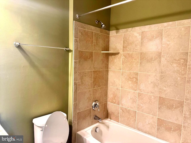 bathroom featuring tiled shower / bath combo and toilet