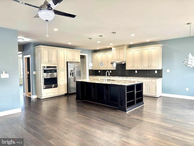 kitchen featuring an island with sink, appliances with stainless steel finishes, dark wood-type flooring, and decorative light fixtures