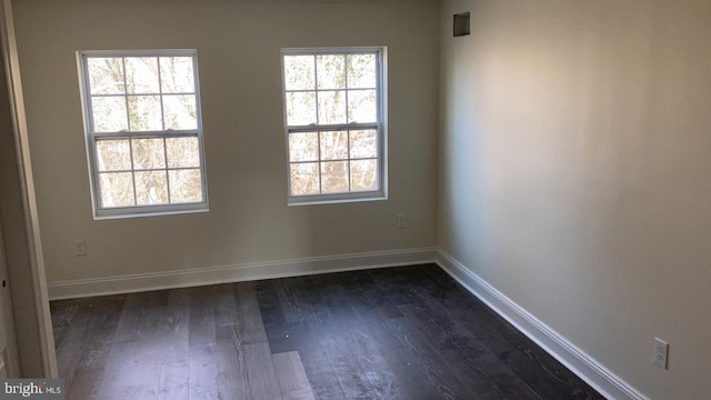 unfurnished room with plenty of natural light and dark hardwood / wood-style floors