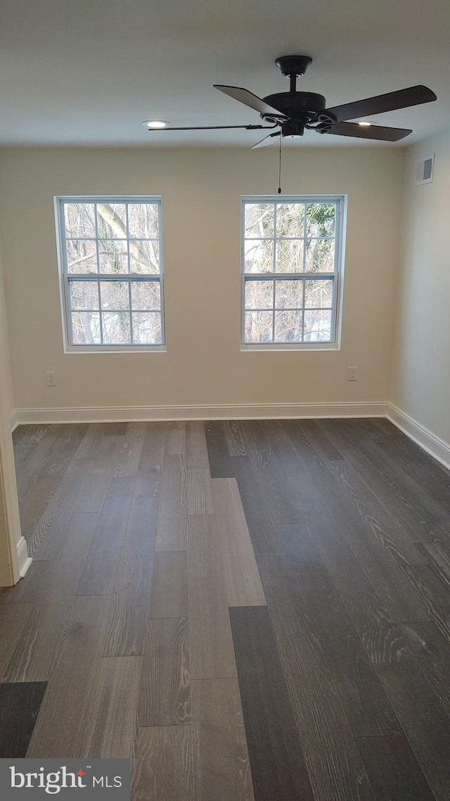 empty room with dark wood-type flooring and ceiling fan