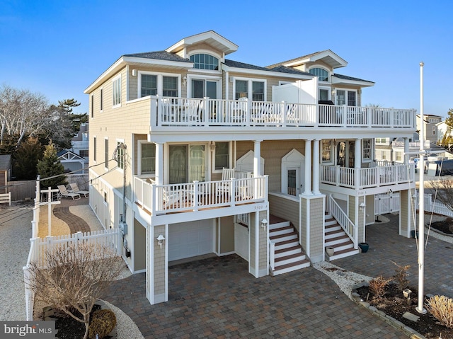 coastal inspired home with a garage and a balcony