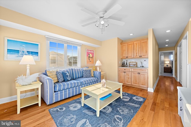 living room featuring ceiling fan and light hardwood / wood-style flooring