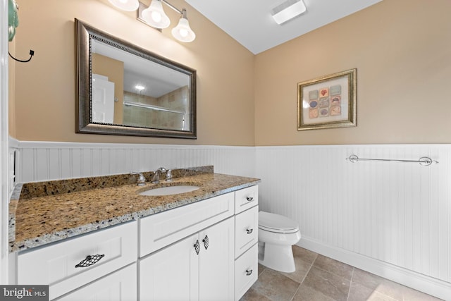 bathroom featuring vanity, walk in shower, and toilet