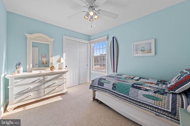 carpeted bedroom featuring a closet and ceiling fan