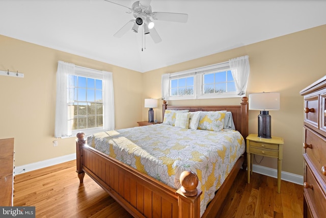 bedroom with ceiling fan, hardwood / wood-style floors, and multiple windows