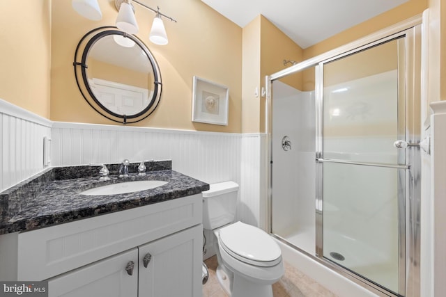 bathroom with a shower with door, vanity, tile patterned flooring, and toilet