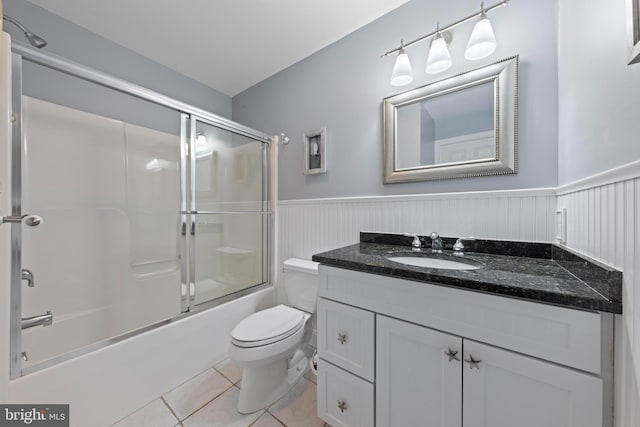 full bathroom with vanity, tile patterned floors, shower / bath combination with glass door, and toilet