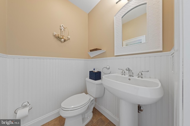 bathroom with sink, toilet, and tile patterned flooring