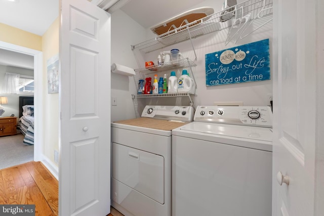 washroom with independent washer and dryer and light hardwood / wood-style floors