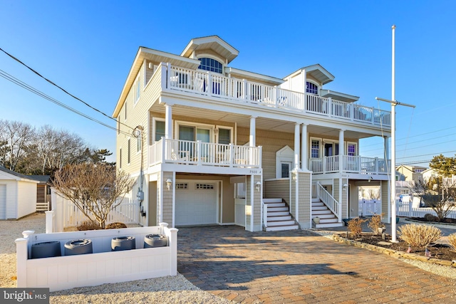 view of front of home featuring a balcony, a garage, and covered porch