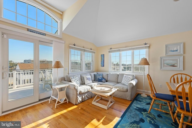 living room with high vaulted ceiling and light wood-type flooring