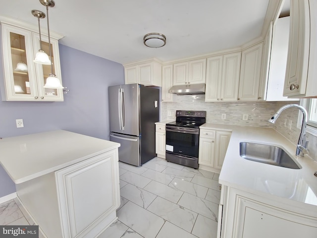 kitchen featuring pendant lighting, sink, stainless steel refrigerator, backsplash, and range with electric cooktop