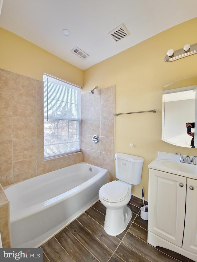 full bathroom featuring vanity, toilet, and tiled shower / bath combo