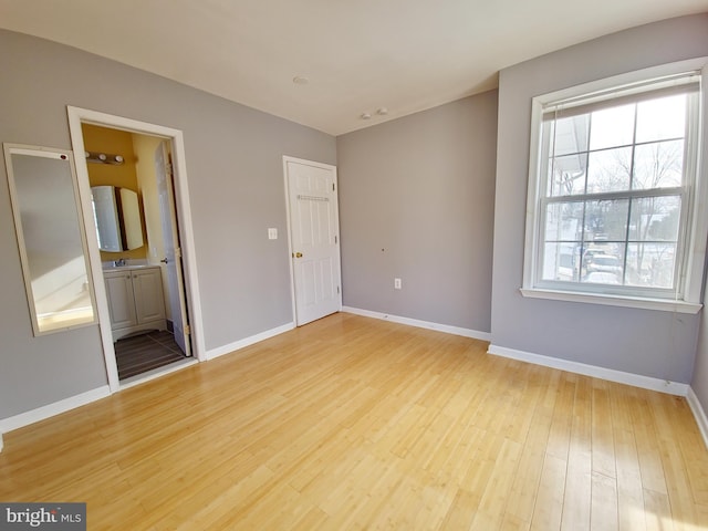 unfurnished room with sink and light hardwood / wood-style floors