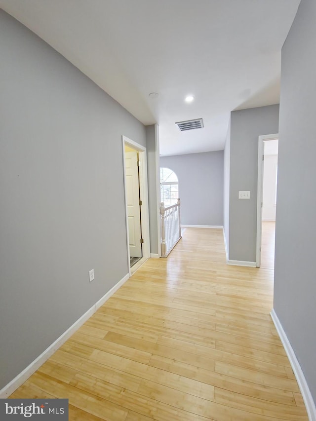 hallway with light hardwood / wood-style floors