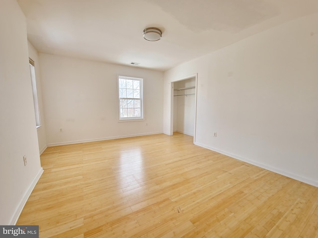 unfurnished bedroom featuring light wood-type flooring and a closet