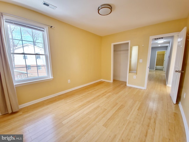 unfurnished bedroom with a closet and light hardwood / wood-style flooring