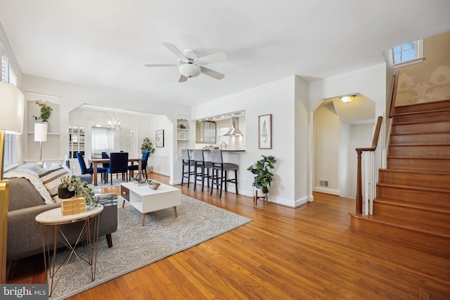 living room featuring hardwood / wood-style floors, ceiling fan with notable chandelier, and a healthy amount of sunlight